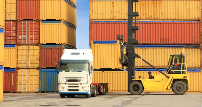 forklift loading containers on white truck in horbor