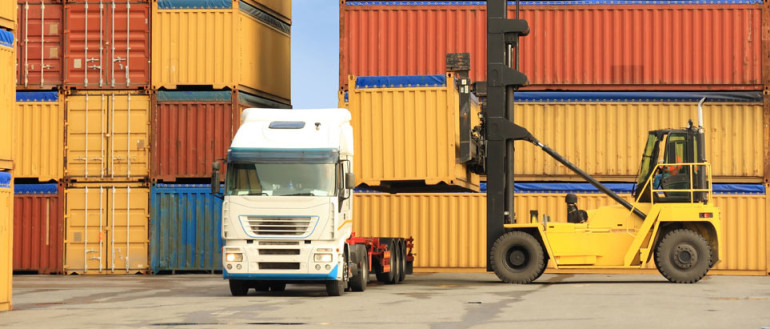 forklift loading containers on white truck in horbor